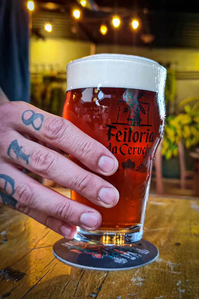 Copo de chopp segurado na mão, em close