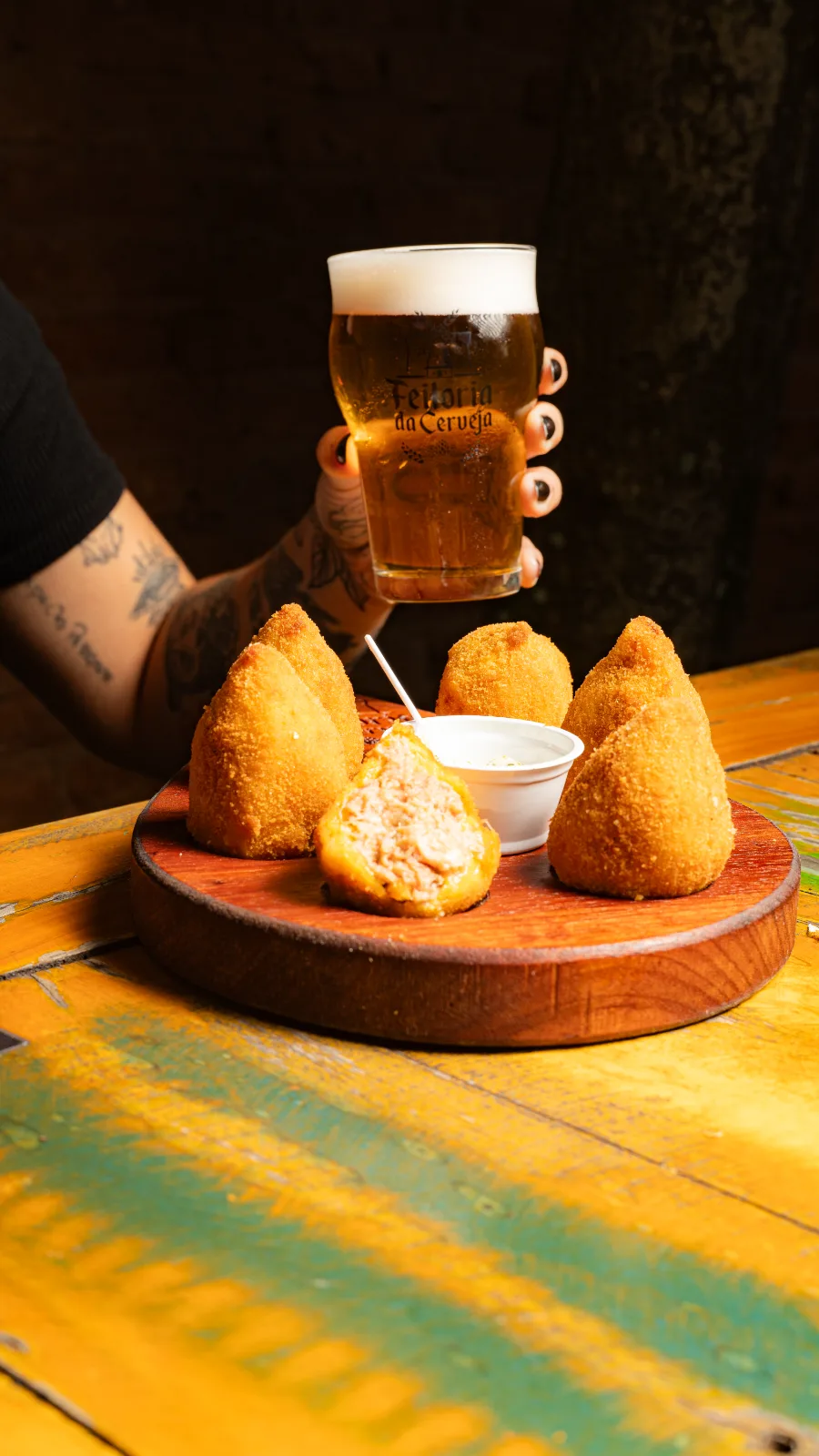 Coxinhas sem massa servidas com molho ao lado de um copo de chopp