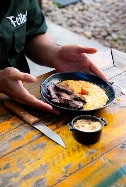 Arroz caldoso com carne defumada servido em prato fundo