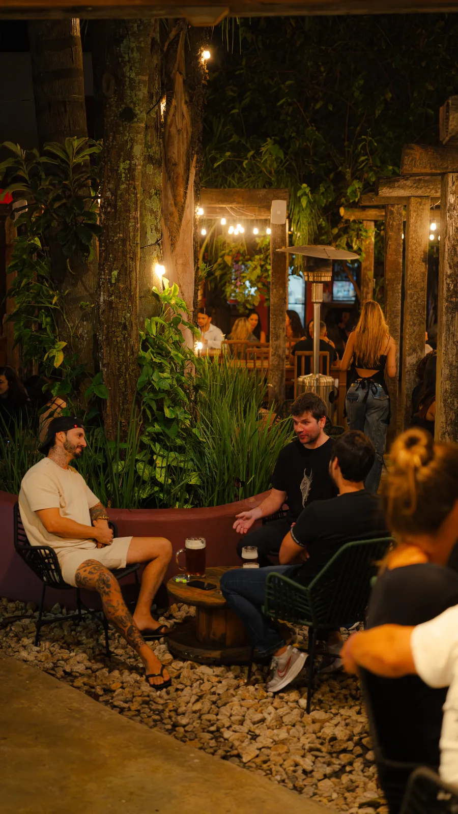 Mesas ocupadas no quintal da Feitoria à noite